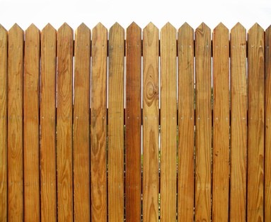 Holzzaun aus senkrechten Brettern mit spitzen Enden
